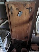 Front view of solid wood cabinet showing single door, hinges, and duct-tape repair