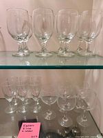 Two shelves showing larger wine goblets on upper shelf and smaller cordial glasses on lower shelf