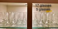 All 22 clear glass footed hurricane vases on shelves, showing height difference between groups