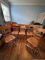 five ladder-back dining chairs lined up showing overall style and quantity