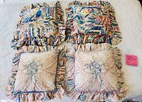 Four pillows laid out showing both patterns and ruffled edges