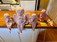 Five pink angel figurines displayed on countertop