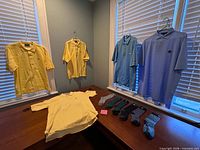 Overview showing five Masters polos (two yellow, two blue, one aqua) and five pairs multicolor socks on table