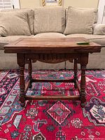 Front view of coffee table with leaves down showing turned legs and stretcher