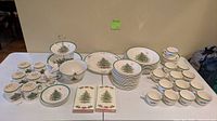 Full set laid out showing plates, bowls, cups, saucers, serving bowl, tiered stand, napkins