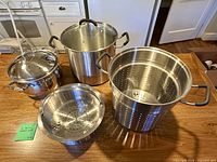 Full view of stock pot, pasta insert, steamer insert and lid displayed on countertop
