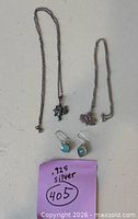 Necklace, bracelet, and earrings arranged on table with .925 note