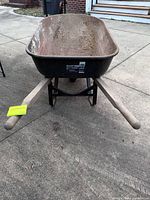 Overall view of True Temper wheelbarrow showing tray, wood handles and front wheel