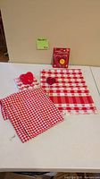 All items displayed: placemats, gingham napkins, packaged cookie cutters, paper napkins, red heart tray, glitter heart pick