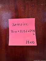 Front close-up of armoire surface with note showing dimensions
