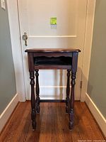 Full front view of side table showing turned legs and overall form