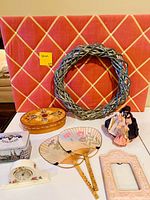Group shot showing all ten items: memo board, wreath, wooden box, tin box, two fans, clock, frame, doll