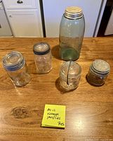 Five of the jars standing with some lids attached, showing colour and size variation