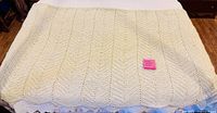 Full view of crocheted afghan spread out, showing ripple pattern and color