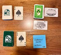 All four decks laid out: two The Cloister decks, shamrock deck, scenic photo deck, Gemaco Ace cards visible, sticky note stating no boxes