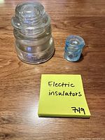 Large clear and small aqua glass insulators side by side