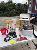 Entire lot on table: Wagner heat gun, power roller unit, measuring cup, scraper, two Wagner boxes