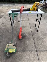 Overall view of three lawn tools on table and ground