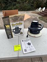Polisher with pad, box and manual displayed on table