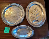 Overview of three silver-plated WM Rogers trays on table