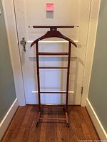 Front view of full valet stand showing hanger, rails and casters