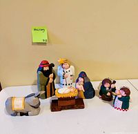 Full group of seven wood nativity figures arranged on table