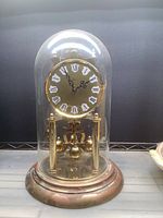 Front view of brass anniversary clock under glass dome