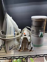 Front view of all three appliances: Hamilton Beach iron, handheld mixer, rechargeable juicer