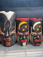 Three wooden masks showing size difference and motifs