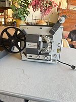 Projector left side with reel arm and controls visible