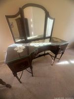 Vanity front view showing tri-fold mirror, drawers, glass top