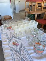 Overall lot on table showing frosted goblets, clear glasses, tumblers and pitcher