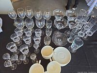 Full lot overview showing assorted stemware, compote bowl, tumbler, porcelain cups and saucers