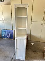 Front view closed door showing shelves and beadboard door