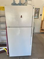 Front view of closed white top-freezer refrigerator