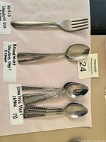 Overview of fork and spoons displaying handle designs and labels