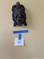 Front view of carved wooden mask on wall