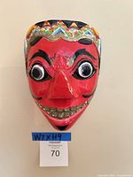 Front view of red Balinese style paper mâché mask showing full face, eyes, mouth, headband