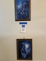 Both framed paintings displayed on wall