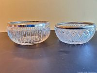 Two cut glass bowls side by side showing exterior patterns and silver rims