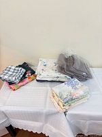 Assorted folded sheets and curtains on table