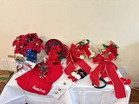 Overview of entire lot on table: poinsettias, bells, bows, Santa sack, tray, garland