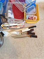 Kitchenware lot showing containers, utensils, dish rack, knives and pot