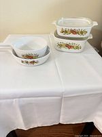 Full lot view with two round skillets and stacked rectangular casseroles with lids