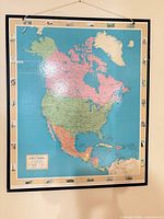 Front view of framed laminated North America wall map on wall