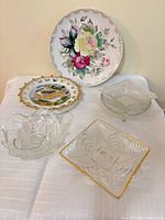Overall lot showing floral charger, souvenir plate, three glass dishes
