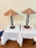 Pair of copper-shade black-base table lamps on tables