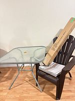 Entire lot showing table, chair with cushion, and boxed umbrella