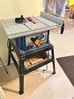 Full view of Ryobi table saw on stand with accessories visible