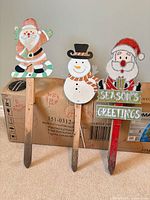 Front view of all three wooden Christmas yard stakes